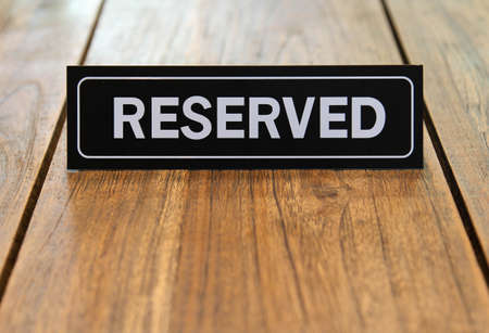 Table sign "RESERVED" on a wooden table.の写真素材