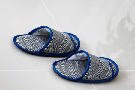 Casual shoes or Slippers for home use on the grey floor tiles.