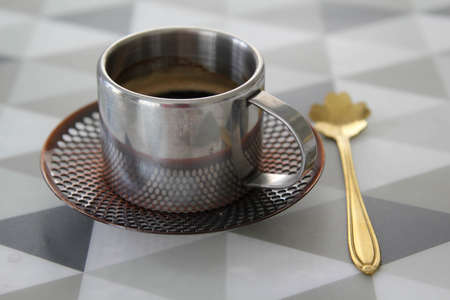 A stainless steel coffee cup with black coffee on the table.の写真素材