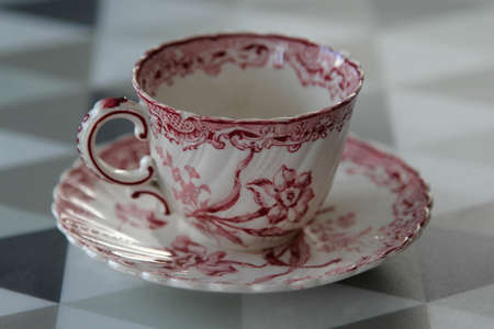 White ceramic coffee cup with pink flower pattern on the table.の写真素材