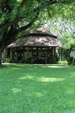 Old wooden style building on green grass lawn.の写真素材