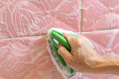 Barehand cleaning the surfaces of ceramic tiles.の写真素材