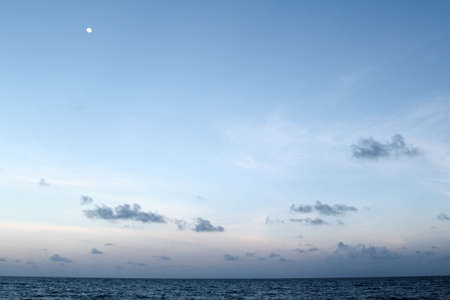 Beautiful landscape of the sea, moon, cloud and blue sky.の写真素材