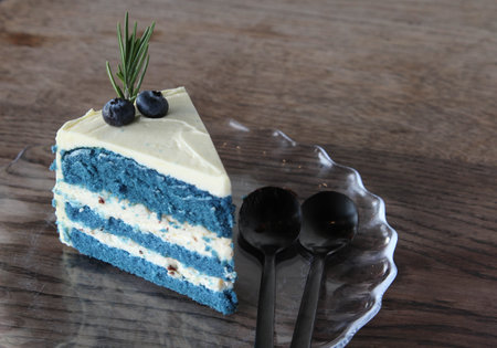 A piece of cake with cream layers on glass plate.
