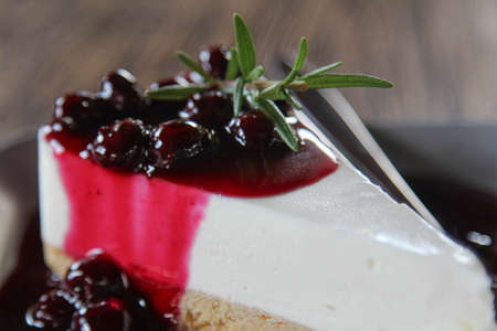 A Slice of Blueberry Cheesecake decorated by rosemary on top.の写真素材