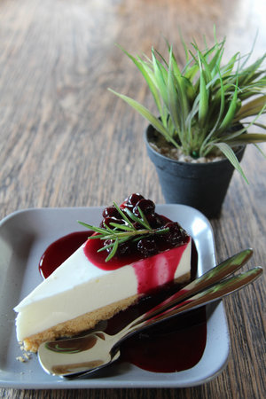 A Slice of Blueberry Cheesecake decorated by rosemary on top.の写真素材