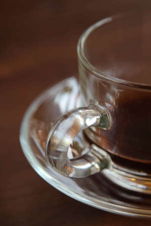 Hot coffee in a clear glass cup after drinking on wooden table.の写真素材