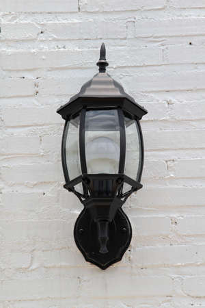 Street lamp on white brick wall.