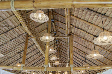 The lamps hang on the thatched roof ceiling.の写真素材