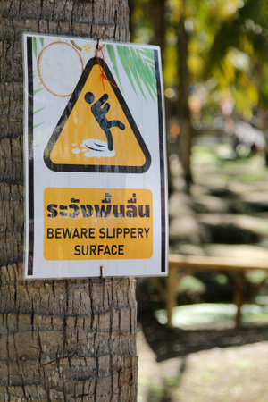 Beware slippery surface sign placed on tree