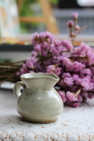 A small ceramic jug on purple flower backgroundの写真素材