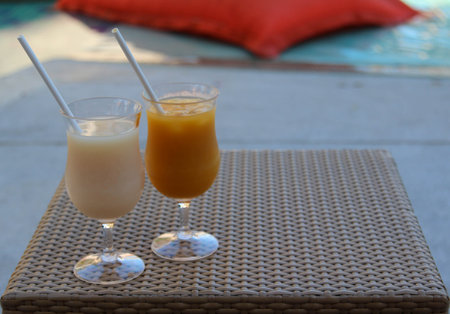 Iced orange juice and iced lychee juice on a rattan tray