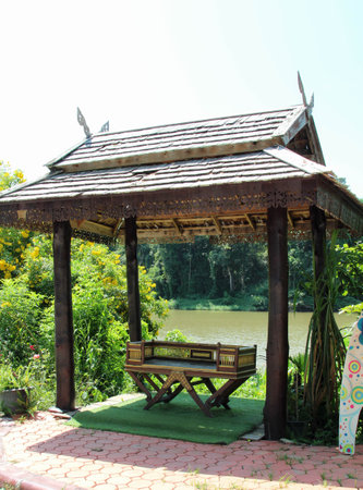 A Northern Thai style wooden bench placed in the wooden pavilion.の写真素材