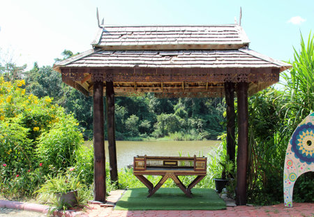 A Northern Thai style wooden bench placed in the wooden pavilion.の写真素材