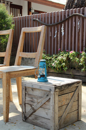 Two wooden chairs with a lamp on the floor.の写真素材