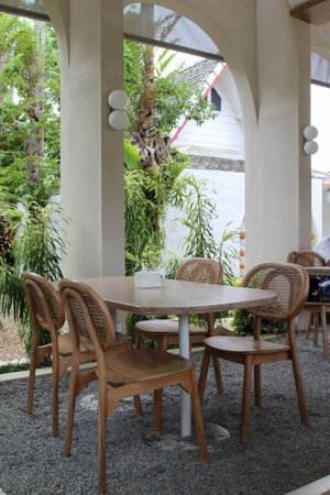 The empty wooden table and chairs for four people set in the restaurantの写真素材
