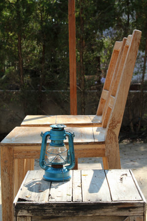 Two wooden chairs with a lamp on the floor.の写真素材