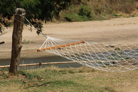 An empty hammock between wooden polesの写真素材