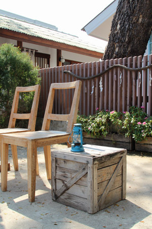 Two wooden chairs with a lamp on the floor.の写真素材