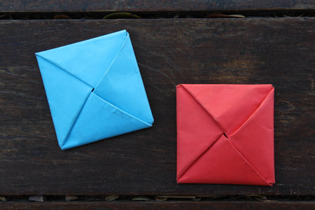 Square origami paper placed on a wooden floor