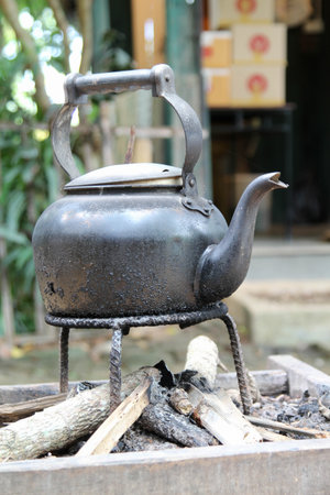 An old vintage kettle on a charcoal stove
