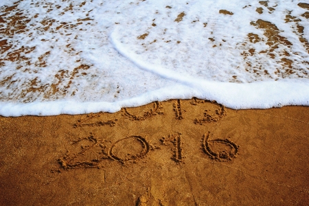 New year 2016 write on sand beach under blue sky and ocean view.