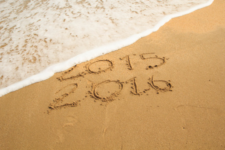 New year 2016 write on sand beach under blue sky and ocean view.