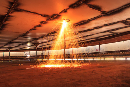 Cutting steel roof storage tank sparks heat  confined.