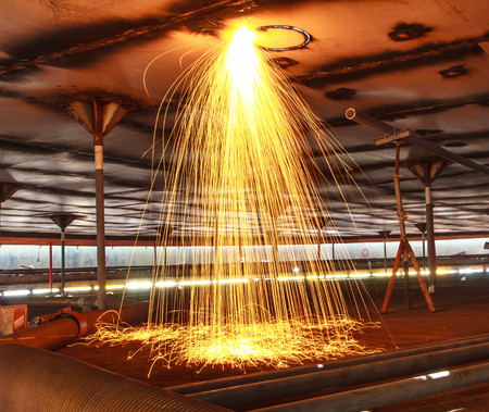 Cutting steel roof storage tank sparks heat  confined.