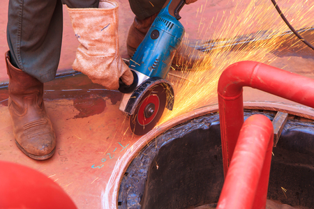 Male  worker wearing protective clothing and repair grinding industrial construction oil and gas or ...