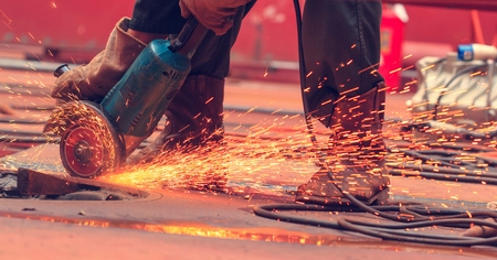 Male  worker wearing protective clothing and repair grinding industrial construction oil and gas or ...