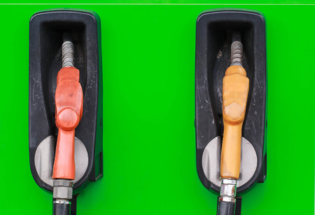 yellow and red petrol gas pump nozzles in a service station background green,Fuel nozzle in oil station Thailandの写真素材