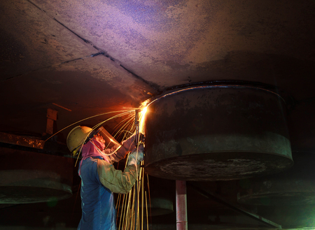Bangkok Thailand - September 10th, 2016: Male  worker wearing protective clothing and Cutting sparks  industrial construction oil and gas or  storage tank inside confined spaces.のeditorial素材
