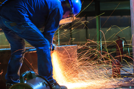 Male  worker wearing protective clothing and repair grinding industrial construction oil and gas or ...