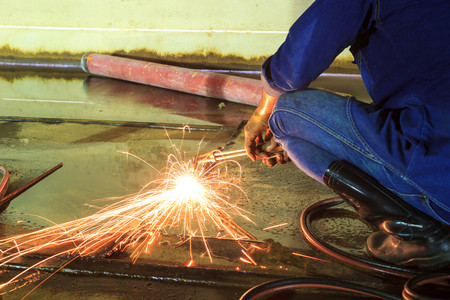 Male  worker wearing protective clothing and Cutting sparks  industrial construction oil and gas or ...