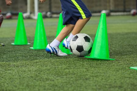 Soccer ball tactics on grass field with cone for training thailand in  background Training children...