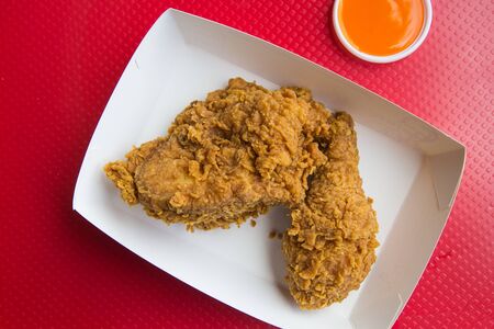 Top view fried chicken and chilli sauce on red background