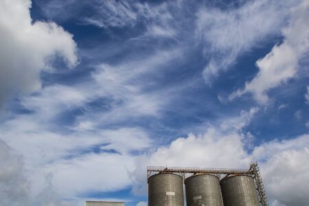 View of silos tank against blue skyの写真素材