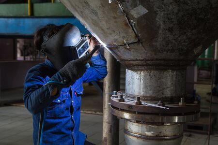 Worker welding repair stainless silo bottom tank using tig welderの写真素材