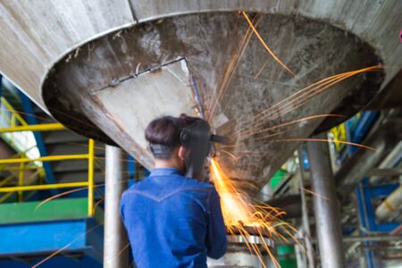 Photo blured Worker grinding repair stainless silo bottom tankの写真素材