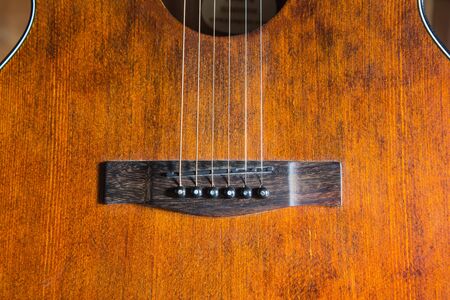 Focus line acoustic line guitar resting against a wooden background