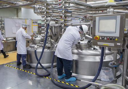 Close the lid tank. - MAY 11th, 2017 : Male two work the process of cream cosmetic fermentation at the manufacturing with stainless tank on the backgroundのeditorial素材