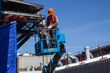 Samutprakan Thailand - June 7th, 2017: Two male industry workers in a boom lift working on high Install the power cord.のeditorial素材