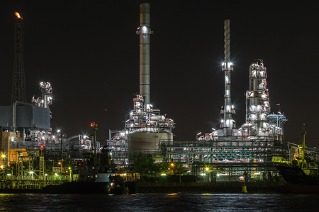 Oil refinery on water side front  at night with oil boat supplyのeditorial素材