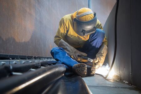 Male  worker wearing protective clothing and repair welding patition plate industrial construction...