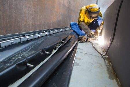 Male  worker wearing protective clothing and repair welding industrial construction oil and gas or ...