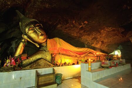 Buddha on stone babkground in cave of Thailandの写真素材
