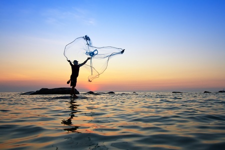 throwing fishing net during sunrise, Thailandの写真素材