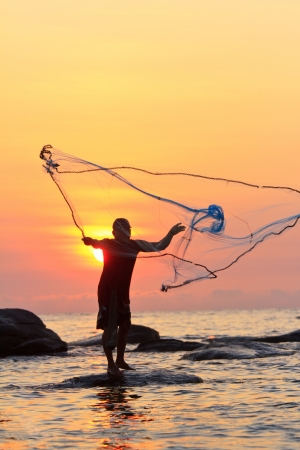 throwing fishing net during sunrise, Thailandの写真素材