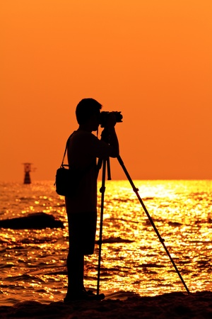 Photographer silhouette shooting sea outdoorsの写真素材